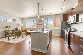a large kitchen with an island and a dining room with a table and chairs